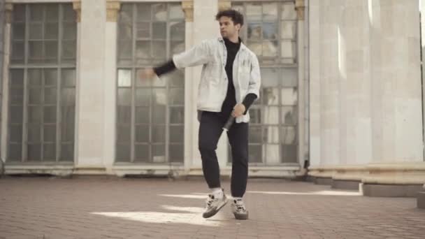 Ampla foto de dançarino realizando break dance no prédio urbano abandonado no dia ensolarado de verão. Retrato de homem caucasiano confiante dançando ao ar livre. Passatempo e estilo de vida. — Vídeo de Stock