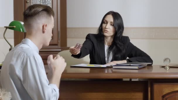 Serious professional psychologist giving pills to depressed frustrated man and talking. Portrait of confident Caucasian woman consulting patient. Mental treatment and health concept. — Stock Video