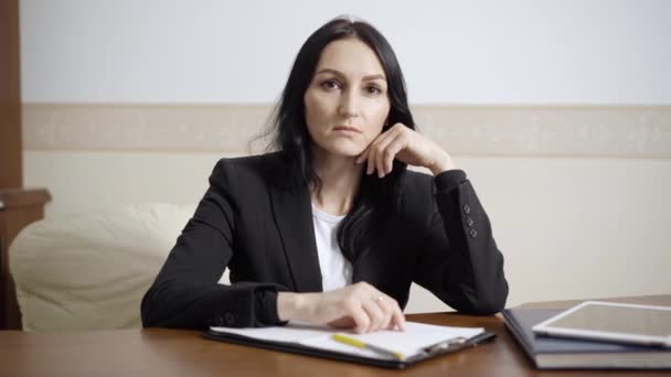 Psicólogo profesional serio confiado sosteniendo la cara en las manos mirando la cámara. Retrato de mujer especialista caucásica posando en oficina en interiores. Concepto de confianza y ocupación. — Vídeo de stock