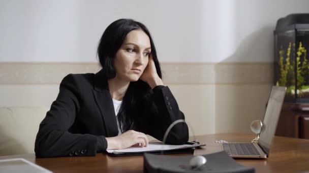 Mujer aburrida y cansada bostezando mientras escucha a la paciente hablando en video chat. Retrato de psicólogo caucásico profesional con exceso de trabajo o médico que consulta a las personas en línea. Agotamiento y cansancio. — Vídeo de stock