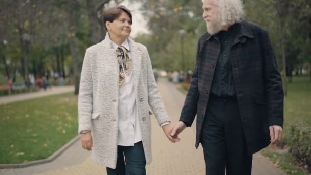 Šťastná dvojice důchodců tančí v uličce podzimního parku. Portrét pozitivního milujícího bělocha manžela a manželky, kteří si užívají randění venku. Věčný koncept lásky a štěstí. — Stock video