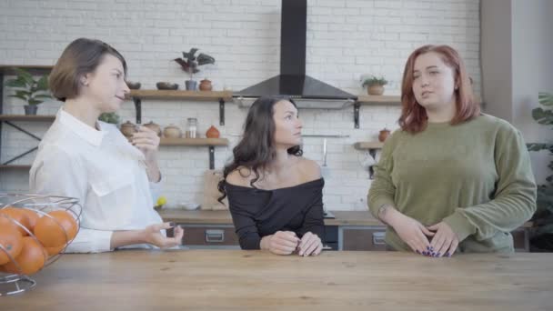 Supportive friends listening to young plus-size Caucasian woman complaining in kitchen at home. Upset redhead lady talking and gesturing. Depression and support concept. — Stock Video