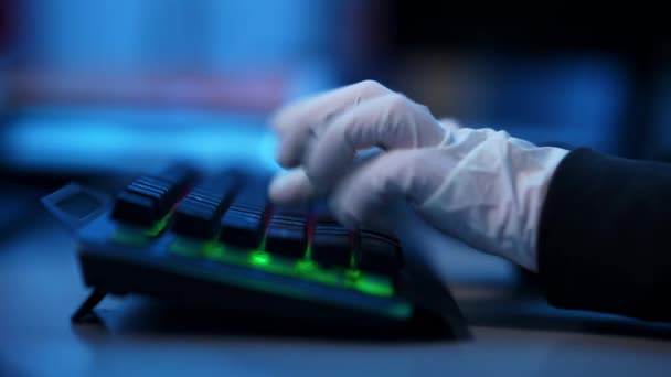 백라이트 키보드로 타이핑하고 있는 흰 장갑을 끼고 있는 손의 근접 사진. 알아볼 수없는 해커 프로그래머 코딩 가상 바이러스 해킹 웹 사이트 실내. 소프트웨어 보안과 범죄 개념. — 비디오