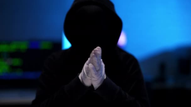 Σιλουέτα αγνώριστου χάκερ με μαύρη κουκούλα να τρίβει τα χέρια σε λευκά γάντια. Ικανοποιημένος προγραμματιστής κωδικοποίησης μέσα στο σκοτάδι. Διαδικτυακή επίθεση και hacking έννοια. — Αρχείο Βίντεο