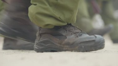 Asker botlu erkek ayakları dışarıda çokgen üzerinde yürüyor. Dışarıda tanınmayan askerler antrenman yapıyor. Ordu hayat tarzını seçer..