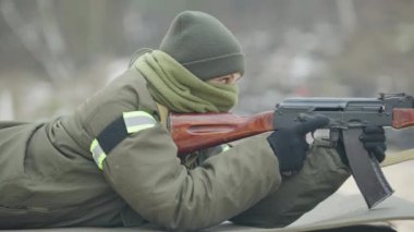Dışarıdaki taktik karemata uzanan kendine güvenen asker kadının yan görüntüsü. Çokgen üzerinde eğitim görmüş güzel beyaz kadın askerin portresi..