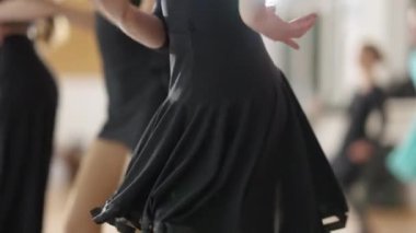 Kafkasyalı genç bir kızın dans okulunda yavaş çekimde caz hareketlerini prova edişinin yan görüntüsü. Sıska yetenekli genç dans stüdyosunda kalça ve elleri oynatıyor..