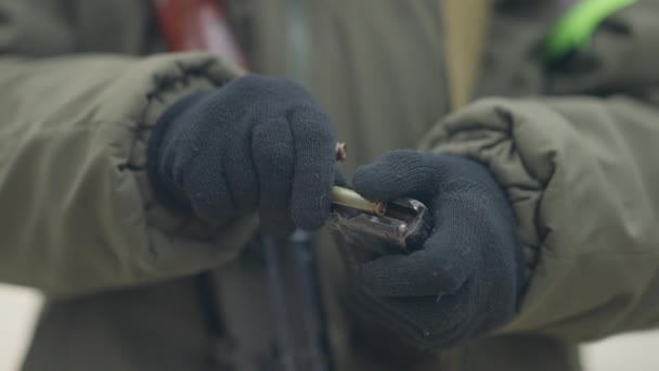 Крупним планом жіночі руки в рукавичках завантажують кулі в журнал. Невідома жінка-солдат заряджає пістолет на відкритому повітрі на полігоні. Військовий спосіб життя і підготовка . — стокове відео