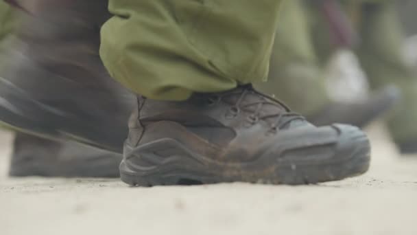 Mužské nohy ve vojenských botách pochodující na venkovní mnohoúhelník. Nepoznatelní vojáci trénují venku. Armáda rekruti životní styl. — Stock video