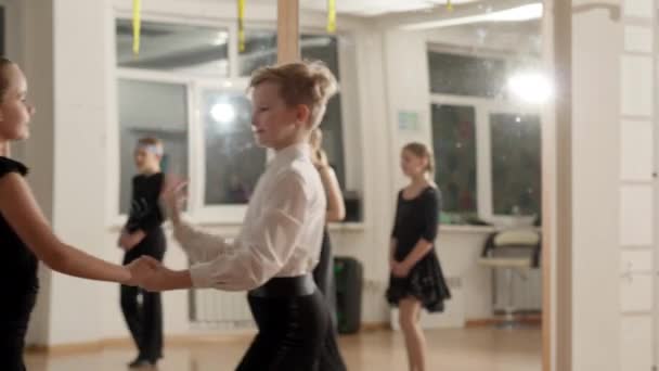 Pareja de niños ensayando samba o baile de rumba en la escuela de baile. Chico y chica caucásicos con talento de confianza bailando bailes de salón latinos en interiores. Ensayo y performance artística. — Vídeos de Stock