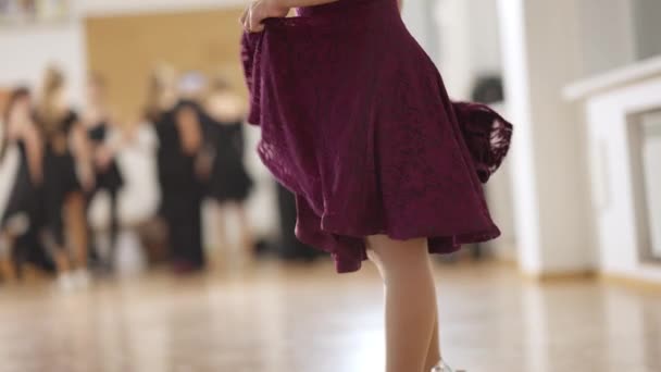 Vista lateral da menina caucasiana magro irreconhecível dançando dança latina em câmera lenta. Criança qualificada a praticar dança de salão na escola de dança. Talento e arte. — Vídeo de Stock