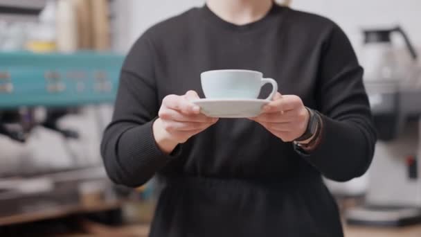 Mujer caucásica irreconocible de talla grande sosteniendo la taza de café azul en la cafetería. Trabajadora de cafetería con bebida caliente en cafetería interior. — Vídeo de stock