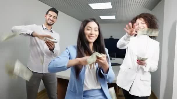 Веселые успешные коллеги, разбрасывающие деньги и танцующие в офисе. Позитивные многонациональные деловые партнеры радуются успеху стартапа в помещении. Концепция богатства и предпринимательства. — стоковое видео