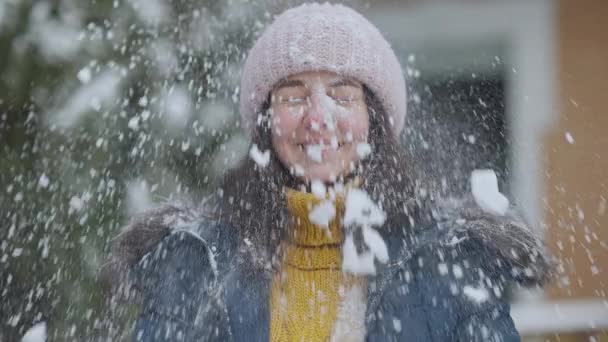 Boule de neige frapper visage de belle jeune femme caucasienne au ralenti. Portrait de rire joyeuse dame charmante s'amuser à l'extérieur en combattant boules de neige. Concept de loisirs et de détente. — Video