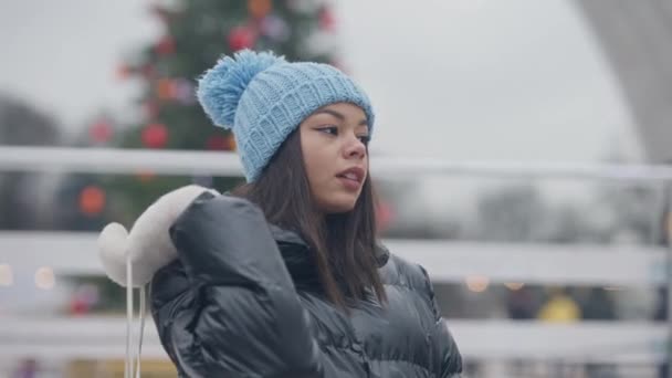Boční pohled portrét atraktivní Afroameričanky držící brusle na rameni obdivující zimní počasí. Krásný štíhlý tisíciletý těší volný čas venku. Zpomalený pohyb. — Stock video
