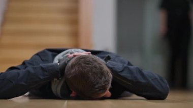 Arka planda yürüyen kimliği belirsiz bir kadın polis olarak polis ışıklarında el ele tutuşarak yerde yatan genç bir suçlu tutuklandı. Talihsiz bir şekilde hırsız ya da katil yakalandı..