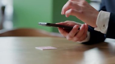 Erkek eli ekranda çalışan akıllı telefonun yakın plan görüntüsü. Restoranda ya da kafede QR kodunu tarayan tanınmayan bir adam. Müşteriler için çevrimiçi menü. Uygunluk kavramı.