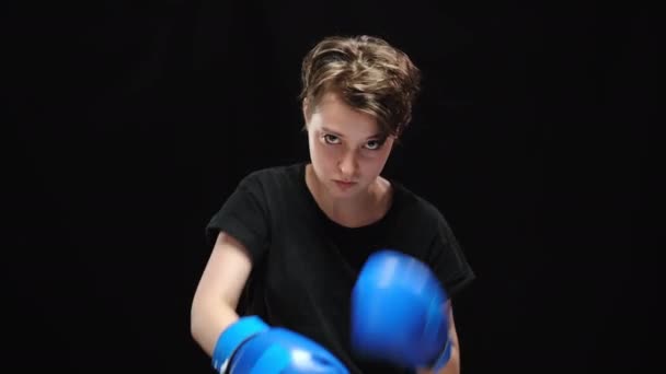 Giovane furiosa donna caucasica ombra boxe guardando la fotocamera. Ritratto di donna bruna oppressa arrabbiata che lotta per la libertà su sfondo nero. Concetto di forza e discriminazione. — Video Stock