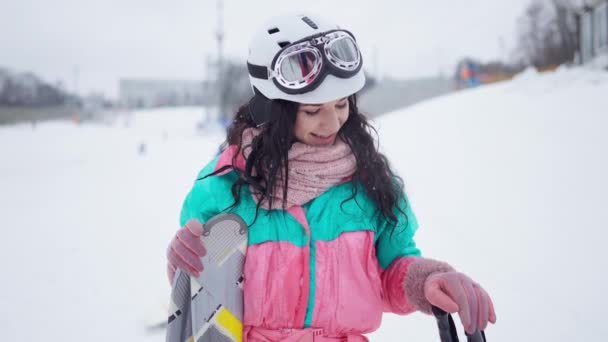 Satisfeito jovem caucasiano magro mulher em terno de esqui posando no resort de inverno mostrando polegar para cima olhando para a câmera sorrindo. Retrato de tiro médio de turista feliz alegre ao ar livre. Movimento lento. — Vídeo de Stock