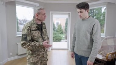 Orta yaşlı asker baba ve yetişkin oğul içeride el sıkışıyor. Kendine güvenen beyaz adamların portresi görev için ayrılan bir asker olarak veda ediyor. Aile ilişkileri ve destek.