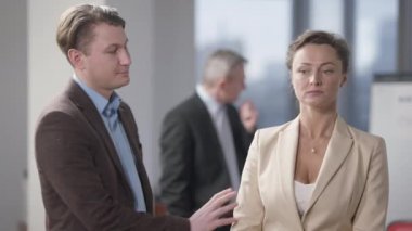 Flört eden adam ofiste güzel bir kadına kur yapıyor. Güler yüzlü beyaz erkek çalışan tatminsiz meslektaşının elini tutuyor. Taciz ve cinsiyet ayrımcılığı.