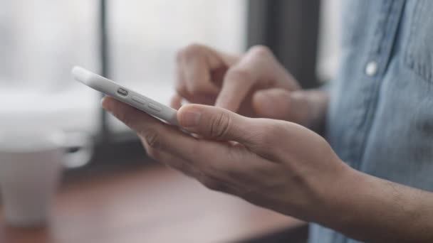 Primer plano de la mano masculina navegar por las redes sociales en el teléfono inteligente en el interior. Mensajería irreconocible del joven de Oriente Medio en línea. Tecnologías modernas y concepto de comunicación inalámbrica. — Vídeo de stock