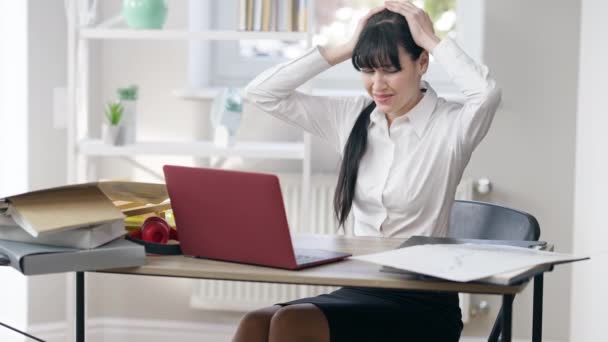 Portrait of overwhelmed young woman sitting in office holding head in hands screaming. Frustrated desperate Caucasian businesswoman having panic attack indoors. Burnout and business. — Stock Video