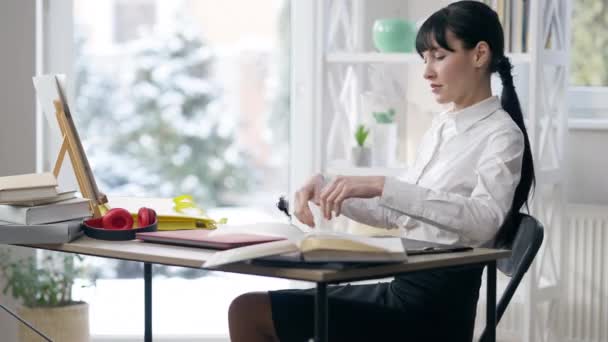 Fiduciosa bella donna d'affari magra seduta alla scrivania e l'apertura del computer portatile. Ritratto di donna caucasica seria concentrata che lavora online in ufficio all'interno. Stile di vita aziendale. — Video Stock