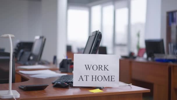 Empty business office with Work at home order printed at computer. No people at workplace on coronavirus pandemic outbreak. Global quarantine and lockdown. — Stock Video