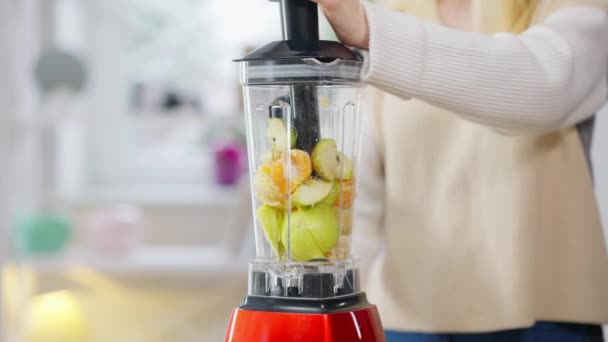 Mujer delgada irreconocible encendiendo licuadora mezclando frutas de vitaminas. Joven ajuste señora caucásica mezcla saludable batido dietético en casa. Vida sana y bienestar. — Vídeo de stock