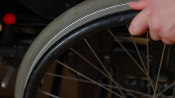 Young female hand rolling wheelchair wheel indoors. Close-up of unrecognizable disabled Caucasian woman leaving. Paralysis and disability concept. — Stock Video