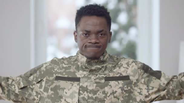 Porträtt av stilig modig säker militär man visar styrka gest tittar på kameran med allvarliga ansiktsuttryck. Modiga afroamerikanska soldater poserar inomhus. Försvarsmaktens koncept. — Stockvideo