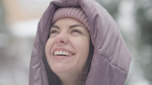 Cabeza de alegre despreocupada hermosa mujer joven con la lengua fuera de la captura de copos de nieve al aire libre. Primer plano retrato de risa alegre caucásico millennial disfrutando de frío clima de invierno. — Vídeos de Stock