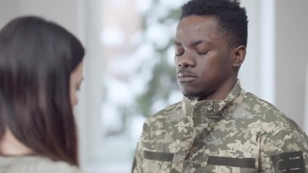 Självsäker snygg afroamerikansk rekryt som står hemma som fru och knäpper militäruniformen. Porträtt av lycklig ung man som lämnar sin make. Kvinnan tar hand om den militära mannen. — Stockvideo