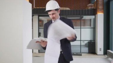 Yorgun profesyonel ustabaşı çizimlere bakıyor inşaat halindeki binalarda iç geçiriyor. Binayı kontrol eden çok çalışan yorgun beyaz adamın portresi..