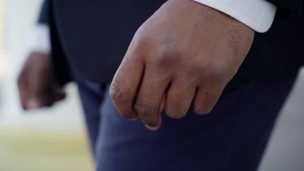 Зблизька афро-американський самець стискає пальці. Неупізнаваний молодий чоловік у костюмі стоїть надворі. Занепокоєння і спосіб життя. — стокове відео
