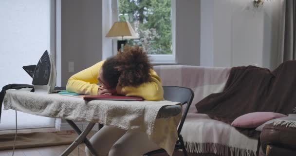 Femme afro-américaine dormant sur planche à repasser sur ordinateur portable au bureau à la maison. Un employé fatigué surmené épuisé et surchargé de tâches multiples lors du confinement en cas de pandémie. Siège social Cinema 4k ProRes. — Video