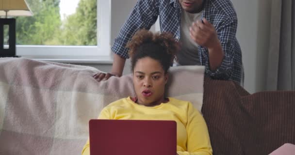 Occupé jeune femme afro-américaine confiante messagerie en ligne comme homme soutenant femme tapant épaule. Portrait de pigiste intelligent concentré dans le bureau à domicile à l'intérieur. Siège social Cinema 4k ProRes. — Video