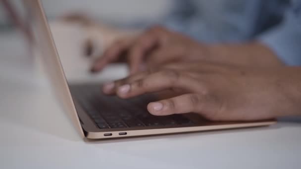 特写非洲裔美国男性的手在笔记本电脑键盘上缓慢打字。无法辨认的专业年轻人在网上发短信，说他们从总部被封锁了. — 图库视频影像