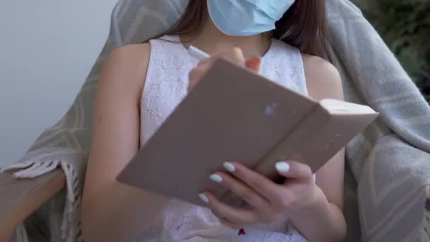 Zbliżenie skoroszytu w kobiece ręce. Nierozpoznawalna młoda kobieta w masce Covid-19 pisząca z pomysłem na strategię biznesową na wypadek pandemii koronawirusa. w biurze. — Wideo stockowe