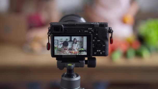 Écran de caméra vidéo avec femme asiatique préparant des ingrédients pour salade végétarienne saine comme blogueur afro-américain recherche recette en ligne sur ordinateur portable. Des amis enregistrant des aliments sains blog dans la cuisine. — Video