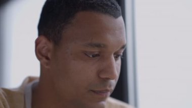 Ofiste kalem planlama fikriyle kafasını kaşıyan düşünceli genç adamın yakın plan yüzü. Akıllı Afro-Amerikan iş adamının kafasından çekilmiş bir portresi..