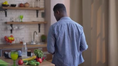 Canlı kamera, iş grafiğiyle mutfakta yürüyen, dizüstü bilgisayarını açıp sandalyeye oturan kendinden emin, Afro-Amerikan ciddi bir adamı takip ediyor. Çalışma saatleri merkez ofiste başlıyor. Yeni normal