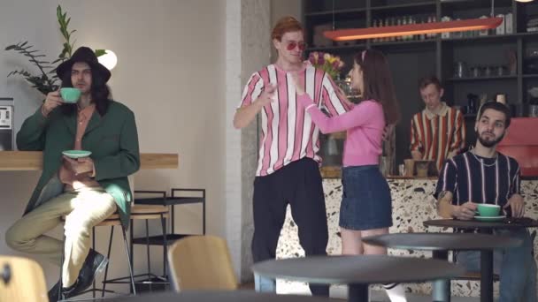 Imádom a retró párokat, akik kávézóban táncolnak az asztaloknál kávézó emberekkel. Pozitív kaukázusi vörös hajú férfi és barna nő szórakoznak a 80-as években. Életmód és társkereső koncepció. — Stock videók