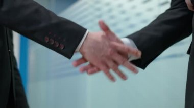 Ofisteki iki iş adamının el sıkışması. Tanımlanamayan kendine güvenen beyaz adamlar el sıkışıyor ve anlaşma yapıyorlar. Anlaşma ve ortaklık kavramı.