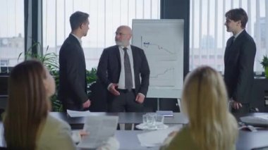 İş ortakları ofis yönetim kurulunda iyi anlaşmalar yapıyor. Ciddi anlamda başarılı erkekler konferans masasında oturmuş gülümseyen kadınlar gibi konuşuyorlar. İşbirliği ve ortaklık.