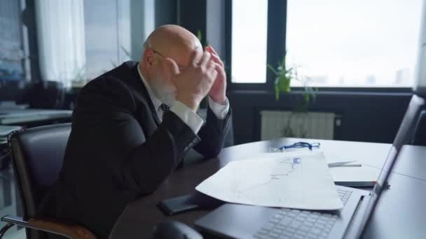 眼鏡を脱いでオフィスの目撃に座っているストレスの多い白人の中年男性の側のビュー。職場での不満男CEOの中出しポートレート。ビジネス上の問題点. — ストック動画