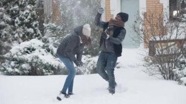 Neşeli Afrikalı Amerikalı, gülen baba ve kızının kış bahçesinde yavaş çekimde kartopu savaşı çekimleri. Mutlu adam ve genç kız dışarıda soğuk havanın tadını çıkarıyorlar..