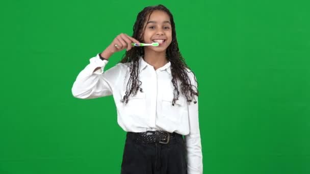 Veselý dospívající dívka napodobující zuby čištění na chromakey pozadí. Pozitivní radostný afroamerický teenager se zubatým úsměvem hledící na kameru pózující na zelené obrazovce. Hygiena a zubní péče. — Stock video