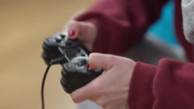 İçeride çok oyunculu video oyunu oynayan bağımlı kadın oyuncuların yakın çekim elleri. Tanımlanamayan beyaz kadın evde oyun oynuyor. Bağımlılık ve yaşam tarzı kavramı.